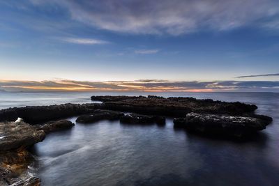 Scenic view of sea against sky at sunset