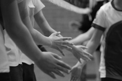 Midsection of boys giving handshake outdoors