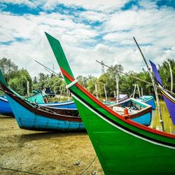 Boats in sea against cloudy sky