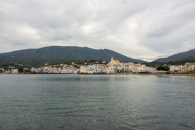 Scenic view of sea by mountains against sky