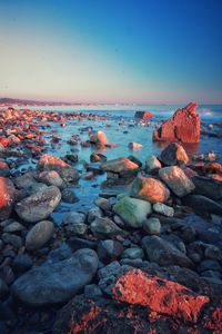 Rocks on beach against clear sky