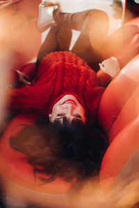 Portrait of a young woman in a warm knitted red sweater outside