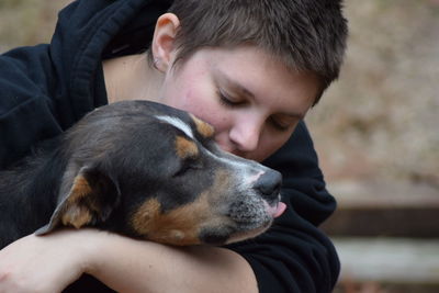 Close-up of young woman pampering dog