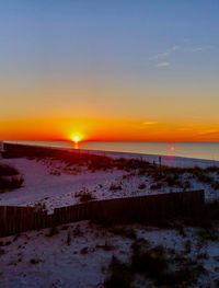 Scenic view of frozen sea against sky during sunset