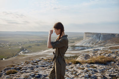 Side view of woman standing on landscape