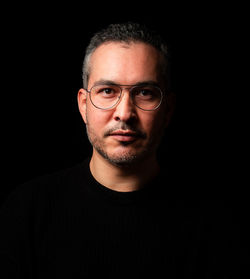 Portrait of mature man against black background