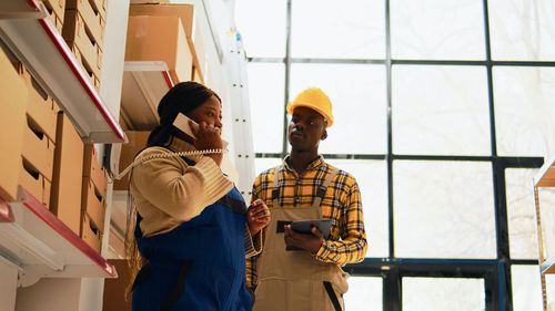 Side view of young man standing against building