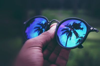 Close-up of hand holding sunglasses