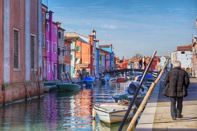 Rear view of senior man walking on footpath at burano