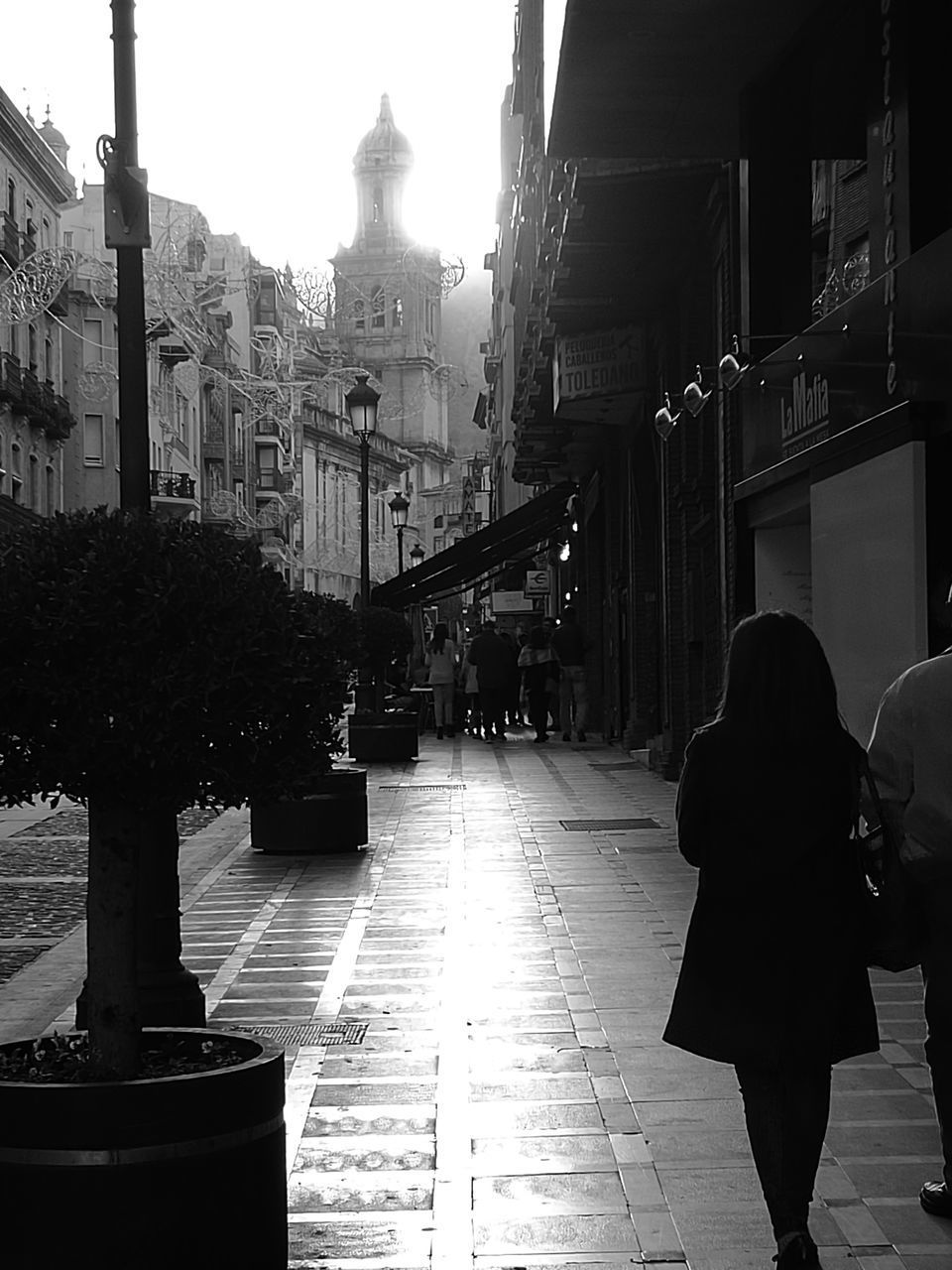FULL LENGTH REAR VIEW OF WOMAN WALKING ON STREET IN CITY