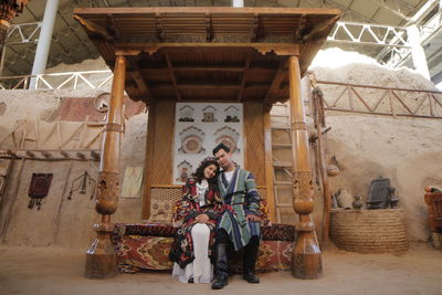 Portrait of smiling couple sitting by temple