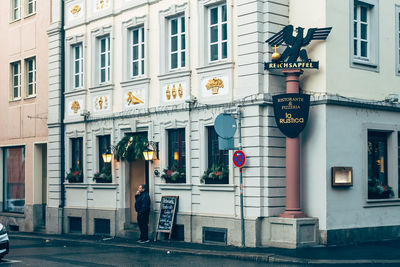 Rear view of man on street against building