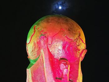 Close-up of illuminated statue against black background