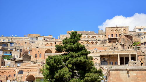 Buildings in city against clear blue sky