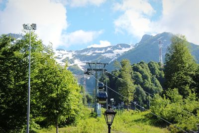 Overhead cable car over mountains against sky