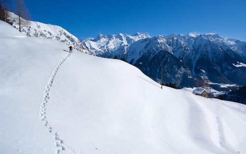 Snow covered mountain against blue sky