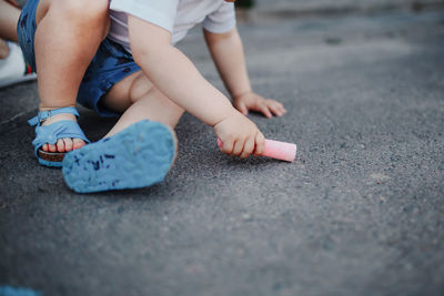 Low section of boy sitting on street