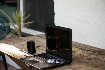 Laptop and drink on wooden table