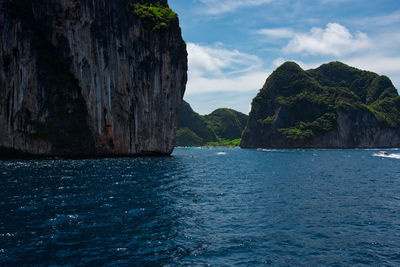 Scenic view of sea by rock formation against sky