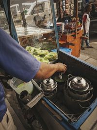 Midsection of worker preparing food at market stall