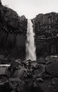 Scenic view of waterfall against sky