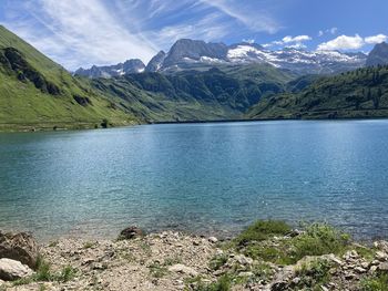 Scenic view of lake by mountains against sky