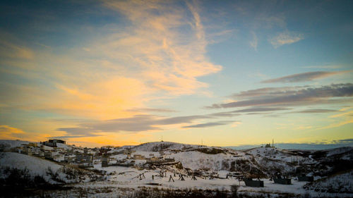 Scenic view of snow covered mountains at sunset