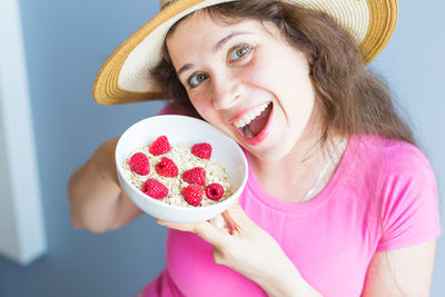 Portrait of woman holding breakfast in bowl