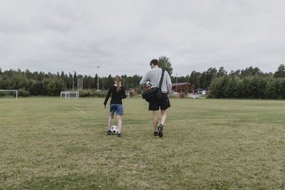 Father and daughter on football pitch