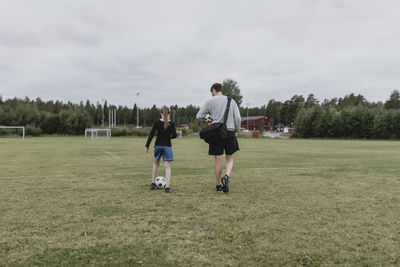 Father and daughter on football pitch