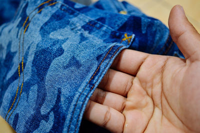 Cropped hand of person holding jeans