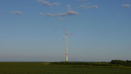 Low angle view of windmill on field against sky