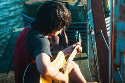 Rear view of man holding guitar