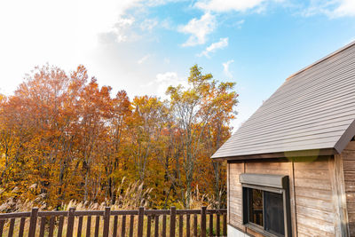 Trees and house against sky during autumn