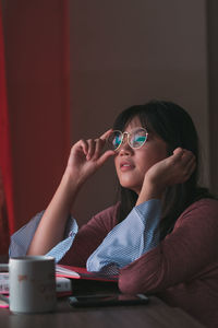 Portrait of a smiling young woman sitting on table