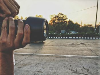 Close-up of man using smart phone against sky