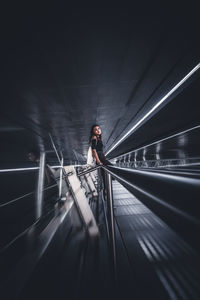 Rear view of woman standing on railway bridge