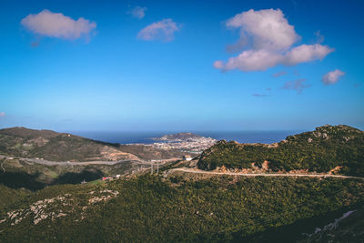 Scenic view of sea and mountains against blue sky