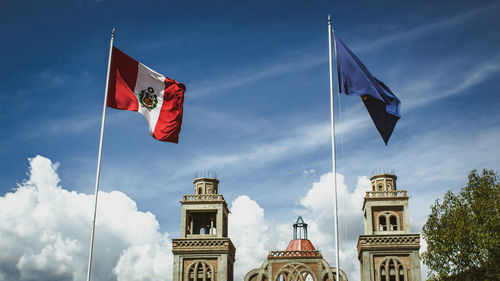 Low angle view of flags on building against sky