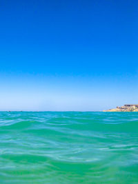 Scenic view of sea against clear blue sky