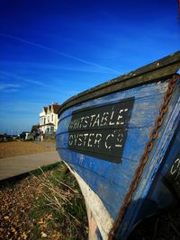 Information sign on field against clear blue sky