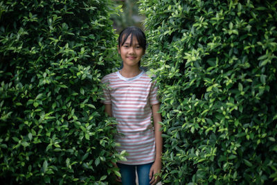 Portrait of woman standing against plants