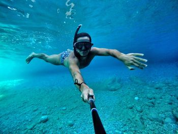 Full length of shirtless man swimming in sea