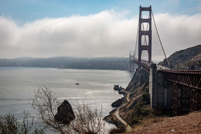 View of suspension bridge against cloudy sky