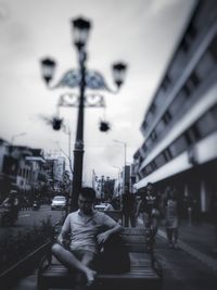 Man sitting at amusement park in city