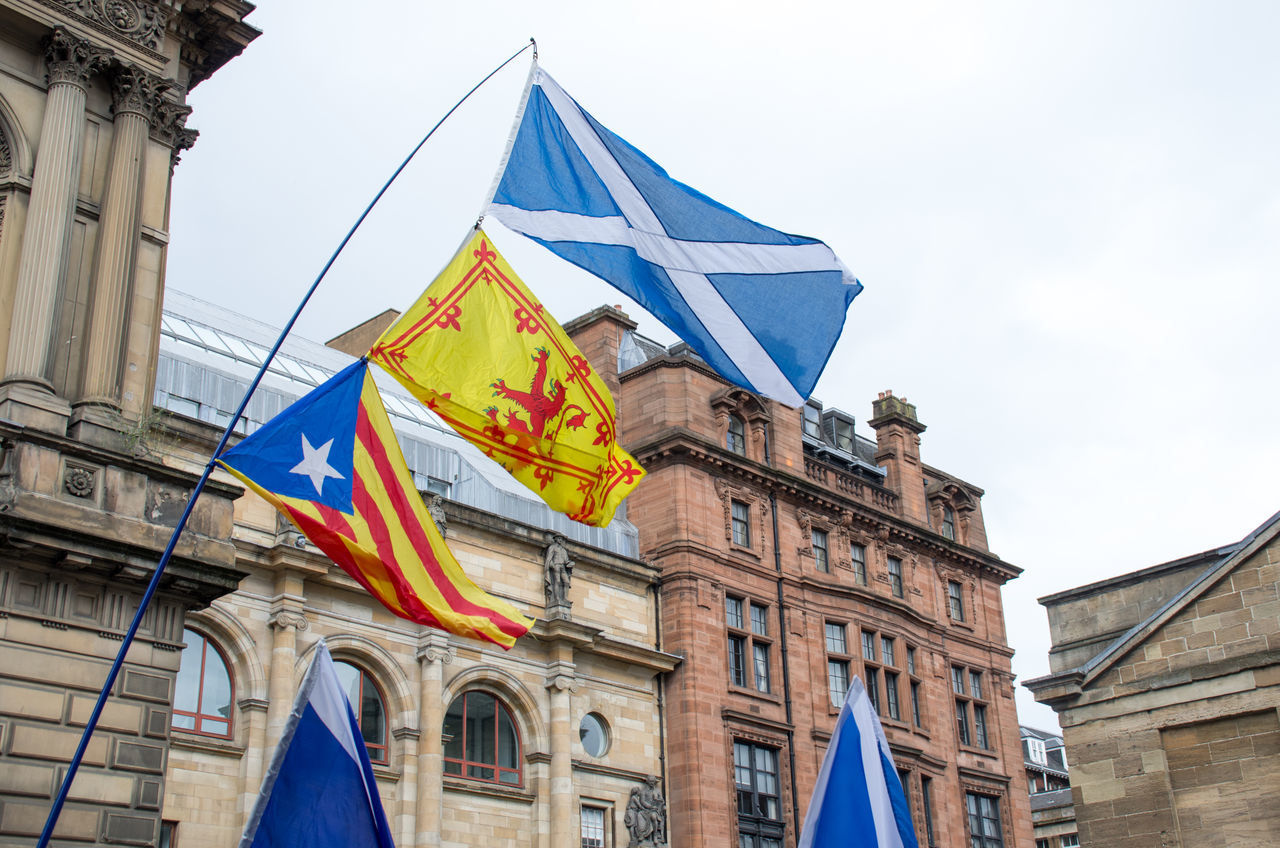 LOW ANGLE VIEW OF FLAG AGAINST BUILDINGS