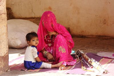 Rear view of a girl sitting on floor