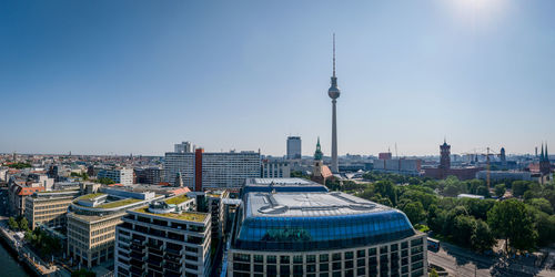 Fernsehturm in city against clear blue sky