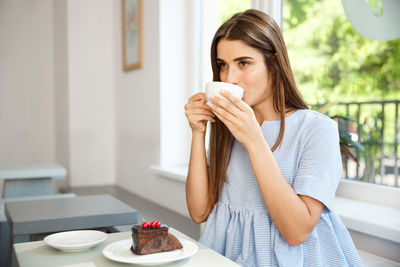 Woman holding coffee cup on table