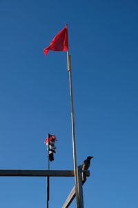 Low angle view of flag against clear blue sky